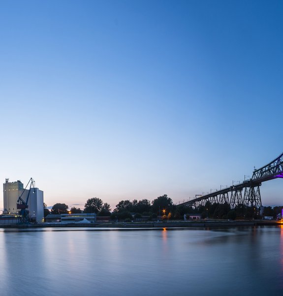 Panoramabild mit Abendstimmung am Kreishafen und an der Eisenbahn-Hochbrücke.